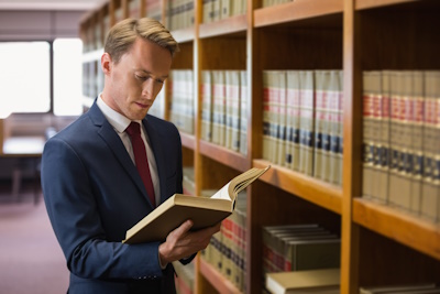 A man is reading a book in a library, McGrath Law Firm, Mount Pleasant Law Firm, Mount Pleasant, S.C.